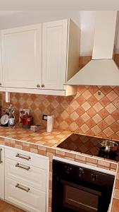 uma cozinha com armários brancos e uma bancada em La mia casa nel Borgo em Scarlino