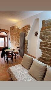 uma sala de estar com um sofá e uma parede de pedra em La mia casa nel Borgo em Scarlino