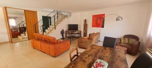 a living room with a wooden table and chairs at Villa climatisée avec piscine et barbecue in Le Grau-du-Roi