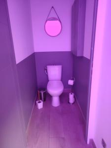 a purple bathroom with a toilet and a mirror at R&M un moment de relaxation in Wardrecques