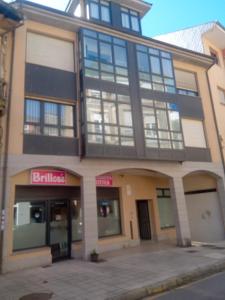 a large building with a store on the side of it at A Bruxo Fonte.8 pzs,2 bañs .Full in Luarca