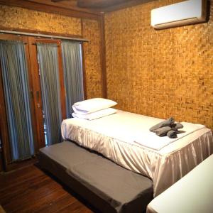 - une chambre avec 2 lits et un ours en peluche sur le lit dans l'établissement Good Vibes Bungalows, à Gili Trawangan