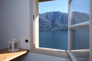 a room with a window with a view of the water at Cozy Suites on the Lake - The House Of Travelers in Brienno