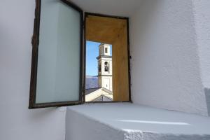 a view of a clock tower through a window at Cozy Suites on the Lake - The House Of Travelers in Brienno