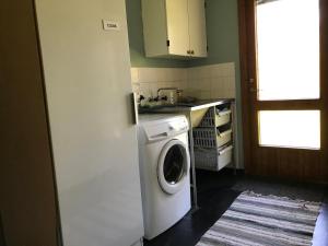 eine Küche mit einer Waschmaschine und einem Waschbecken in der Unterkunft House on Ingmarsö - in Stockholm archipelago in Ingmarsö