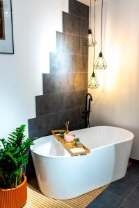 a white bath tub in a bathroom with a plant at Thome Ego Flat in Cluj-Napoca