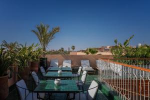 um pátio com mesas e cadeiras numa varanda em Riad Le Saadien em Marrakech