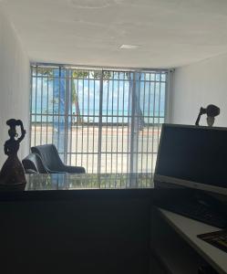 an office with a desk with a computer and a window at Jampa Mar Pousada in João Pessoa