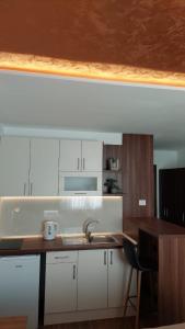 a kitchen with white cabinets and a sink and a counter at Studio Enigma in Bajina Bašta