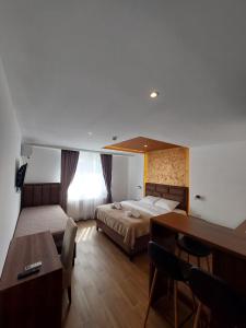 1 dormitorio con cama, escritorio y mesa en Studio Enigma en Bajina Bašta