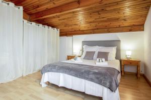 1 dormitorio con 1 cama grande y techo de madera en Charming typical house with garden - Bénesse - Welkeys, en Bénesse-Maremne