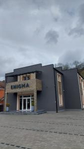 un edificio negro con un cartel en el costado en Studio Enigma en Bajina Bašta