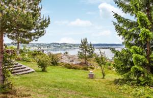 SundsandvikにあるBeautiful Home In Uddevalla With House Sea Viewの水辺の芝生に座る者