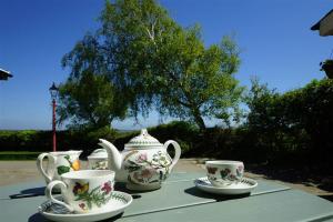 a group of tea cups and saucers on a table at Tyddyn Crythor in Llangadwaladr