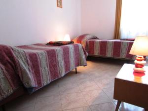 um quarto com duas camas e uma mesa com um candeeiro em Apartments Paliska em Umag