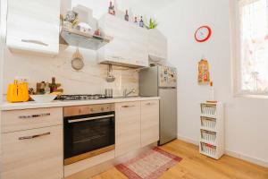 a kitchen with white cabinets and a stove top oven at Affitti Brevi Toscana - In Centro a Porto Ercole in Porto Ercole