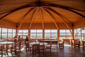 a dining room with tables and chairs and windows at Dakhla Camp in Dakhla