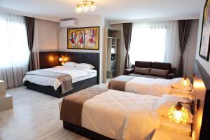 a hotel room with two beds and a couch at SAR-PER Hotel in Edirne