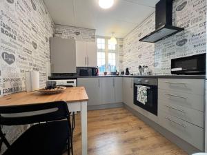 a kitchen with white cabinets and a wooden table at Rest Boutique Notting Hill Age 21 - 60 in London