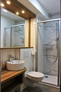 a bathroom with a sink and a shower and a toilet at Hotel Ammerländer Hof in Westerstede