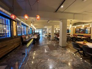 a restaurant with tables and chairs and lights at Hotel Ammerländer Hof in Westerstede