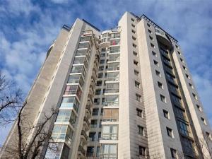 a tall white building with a sky in the background at Lake view luxury apartment in Bucharest