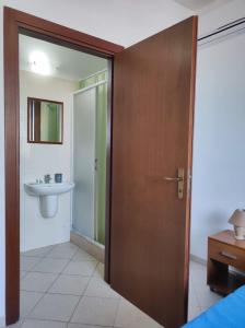 ファヴィニャーナにあるCalamoni22のバスルーム(シンク、木製のドア付)