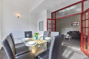 a dining room with a glass table and chairs at Pleasure Holiday Apartments in Blackpool