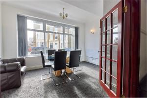 Habitación con mesa, sillas y ventana en Pleasure Holiday Apartments en Blackpool