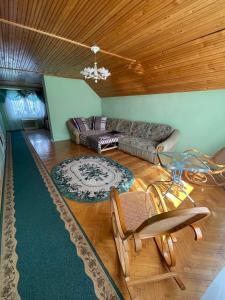 - un salon avec un canapé, une table et des chaises dans l'établissement Golden Sun (3-х кім. Апартамент 7 км від Берегова), à Beregi