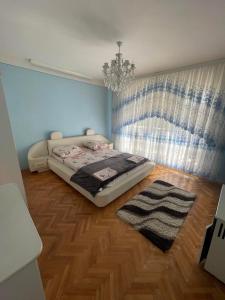 - une chambre avec un lit et un lustre dans l'établissement Golden Sun (3-х кім. Апартамент 7 км від Берегова), à Beregi