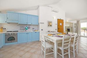 a kitchen with blue cabinets and a table and chairs at Apartmani Paliska in Pula