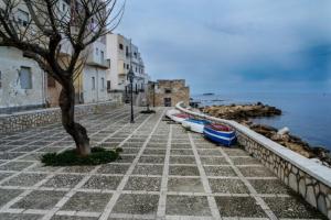 a sidewalk with boats on it next to the water at casa del parco vista mare in Trapani