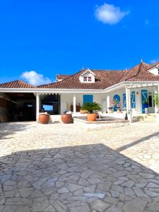 a large house with a stone patio at Villa La Roserie in Ducos