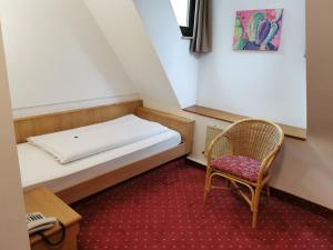 a small room with a bed and a chair at Landhotel Ölmühle in Mömbris