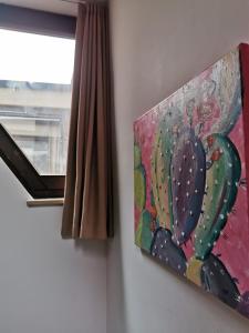 uma pintura de um cacto numa parede ao lado de uma janela em Landhotel Ölmühle em Mömbris