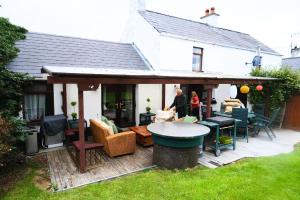 a man and woman standing on a wooden patio at Authentic Irish Cottage, Rural Ballymascanlon in Ballymascanlan