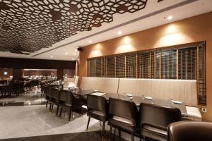 a dining room with a long table and chairs at Pharos Hotels in Chennai