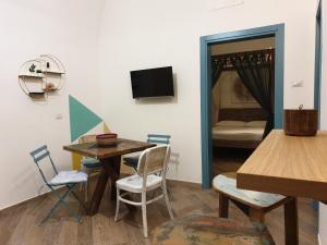 sala de estar con mesa, sillas y TV en La Casetta di Zoe Apartment, en Molfetta
