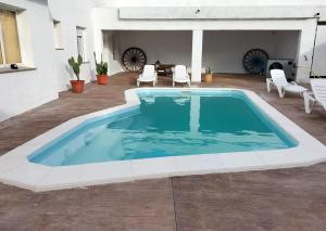 una gran piscina en medio de un patio en Casa Carmen una casa rural con piscina climatizada 