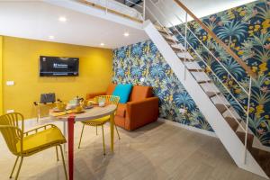 a living room with a staircase and a table and chairs at La Casetta a Sorrento in Sorrento
