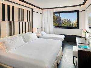 バルセロナにあるH10 マリーナ バルセロナのベッド2台と窓が備わるホテルルームです。