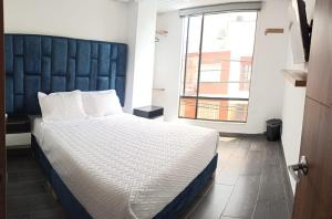 a bedroom with a large bed with a large window at Hotel Everest Chia Oficial in Chía