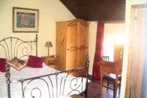 1 dormitorio con cama, escritorio y piano en Authentic Irish Cottage, Rural Ballymascanlon, 