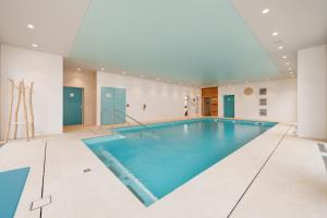 a large swimming pool in a building with a large ceiling at Domitys La Cristal'In in Nancy