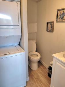 uma pequena casa de banho com um WC e um frigorífico em Beachwood Bungalow A em Carolina Beach
