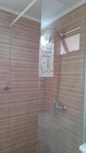 a bathroom with a shower with a sign on the wall at Alquileres Luis in San Clemente del Tuyú