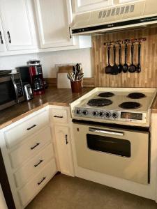 a white kitchen with a stove and a microwave at Driftwood Cottage in Carolina Beach