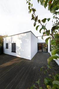 Casa moderna con paredes blancas y suelo de madera. en Barbara' s Guesthouse, en Watou
