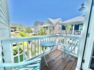 uma varanda com uma mesa e vista para uma casa em Chubby Seahorse 1 em Carolina Beach